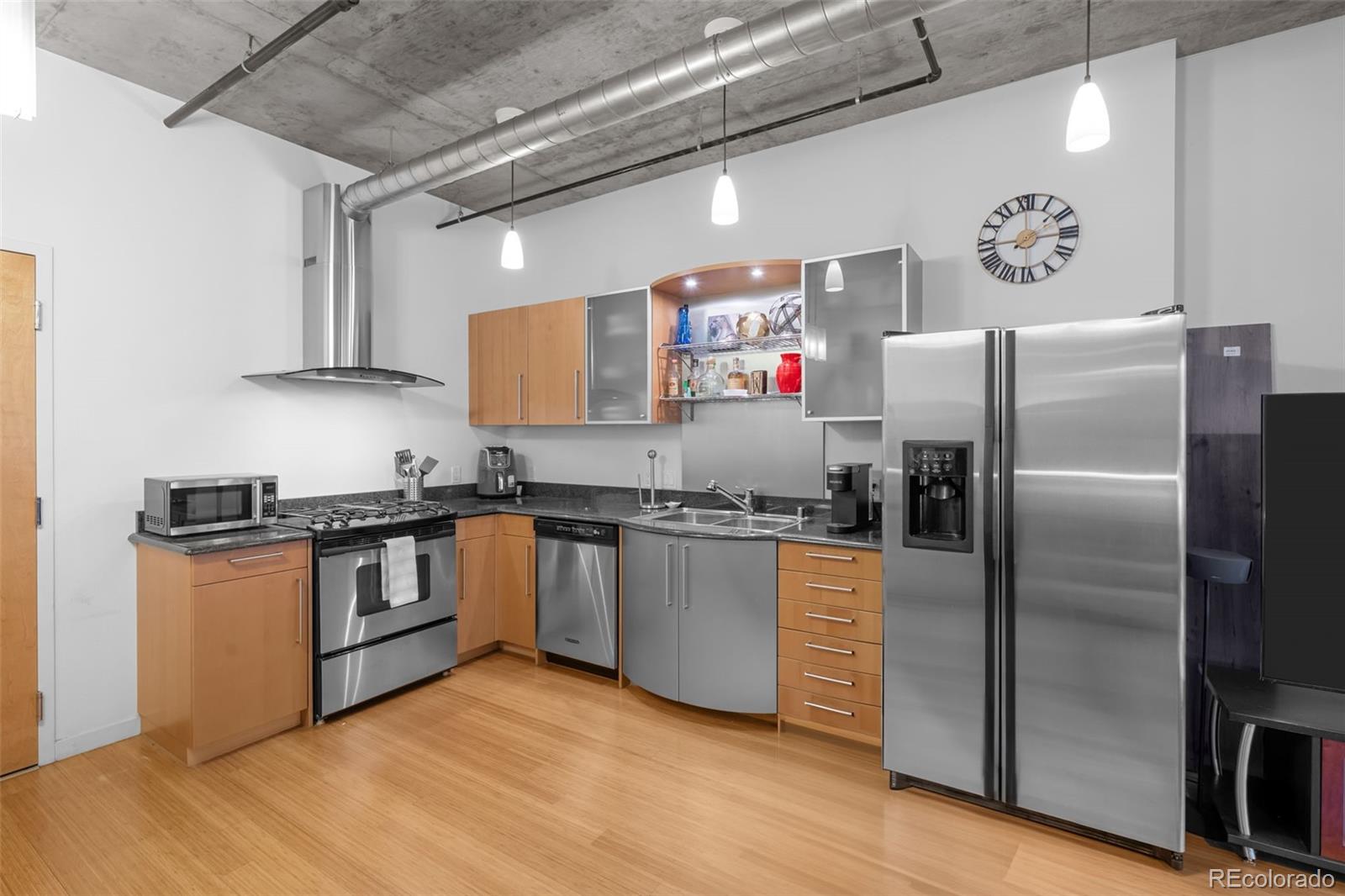 1401 Wewatta Street, Unit 311 Denver, CO 80202 - Photo 9 of 34 a kitchen with granite countertop a refrigerator and a stove top oven