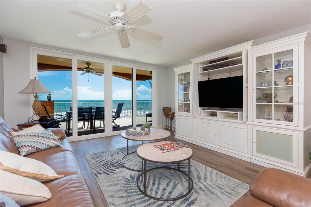 a living room with furniture a flat screen tv and a floor to ceiling window
