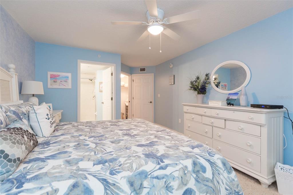 16326 Gulf Boulevard, Unit 109 Redington Beach, FL 33708 - Photo 21 of 63 a bedroom with a large bed and a chandelier