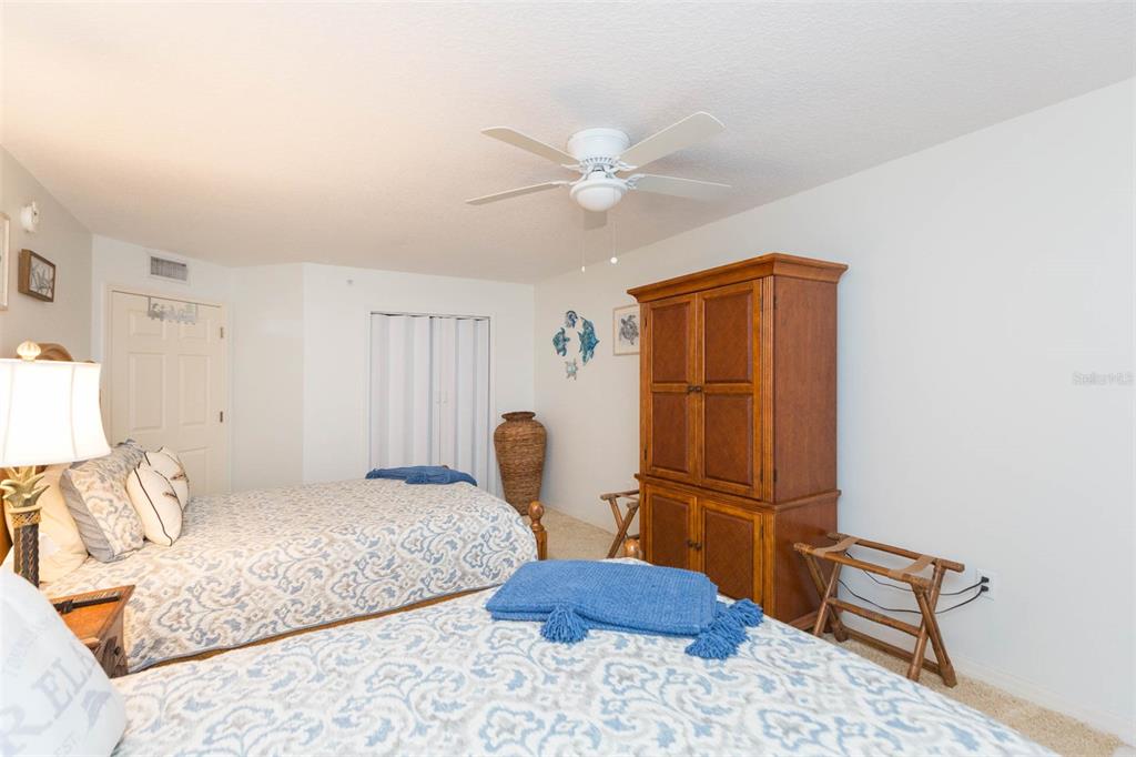 16326 Gulf Boulevard, Unit 109 Redington Beach, FL 33708 - Photo 27 of 63 a bedroom with a bed and a dresser with wooden floor