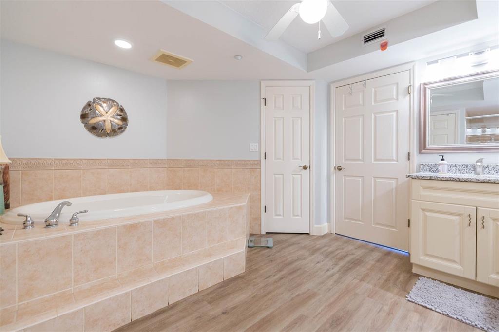 16326 Gulf Boulevard, Unit 109 Redington Beach, FL 33708 - Photo 39 of 63 a bathroom with a tub sink and a mirror