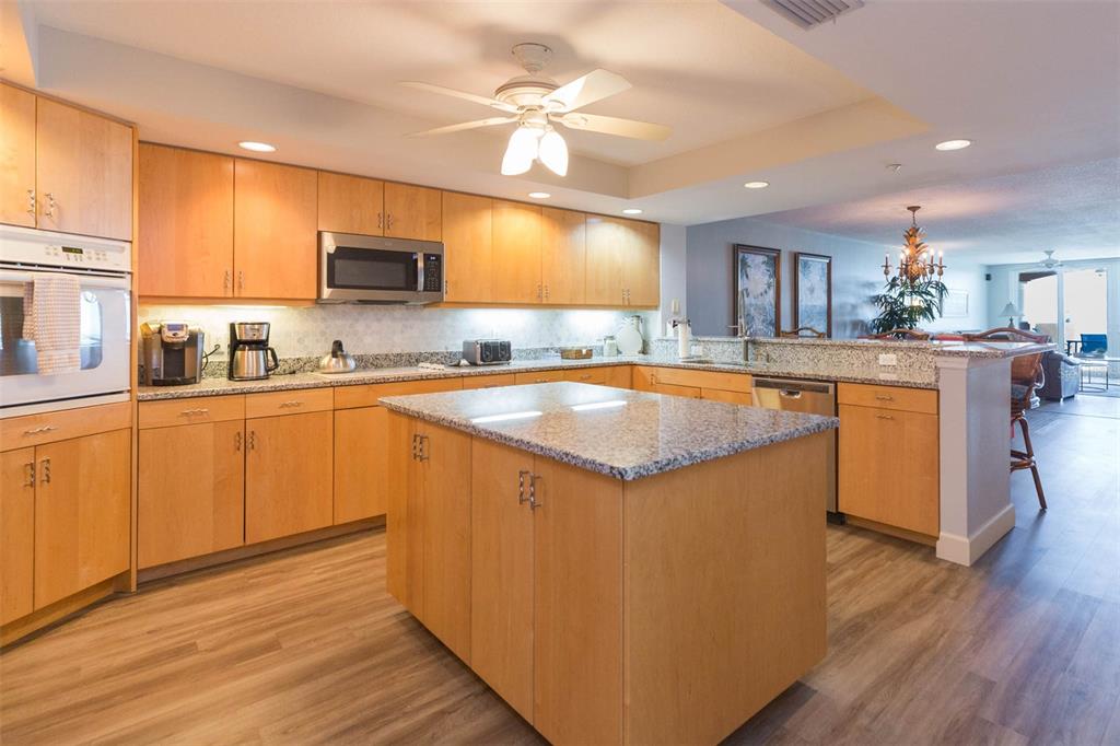 16326 Gulf Boulevard, Unit 109 Redington Beach, FL 33708 - Photo 7 of 63 a kitchen with wooden floors a sink and appliances