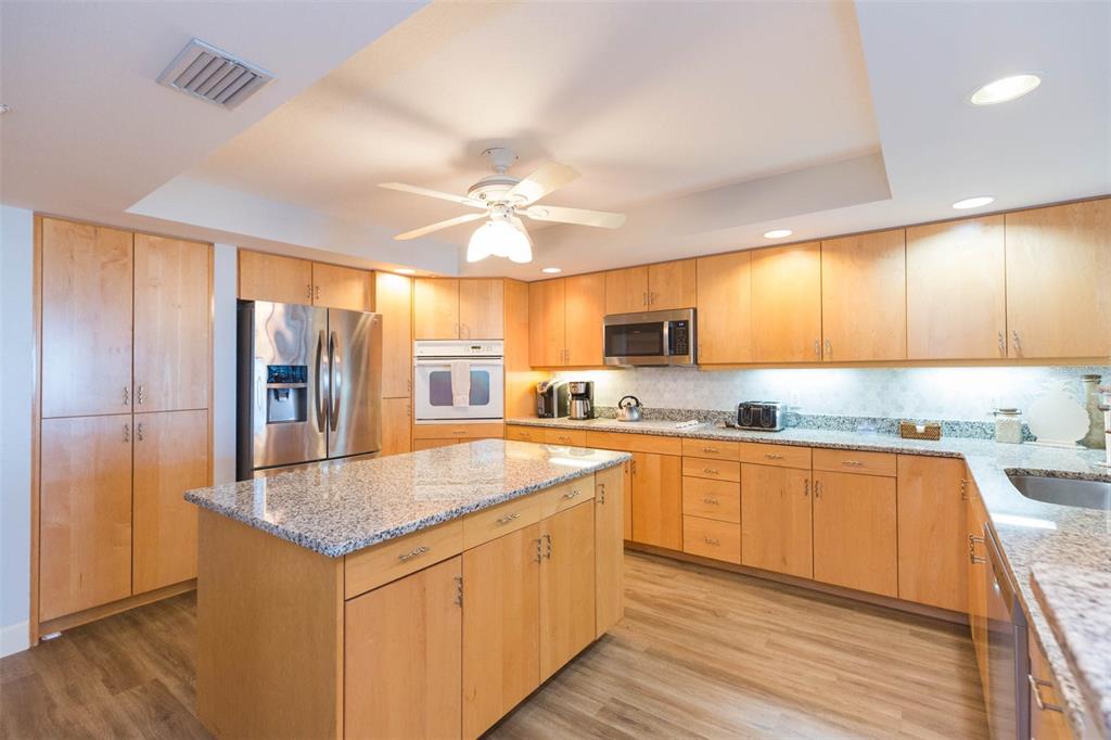 16326 Gulf Boulevard, Unit 109 Redington Beach, FL 33708 - Photo 8 of 63 a kitchen with stainless steel appliances granite countertop a sink and cabinets