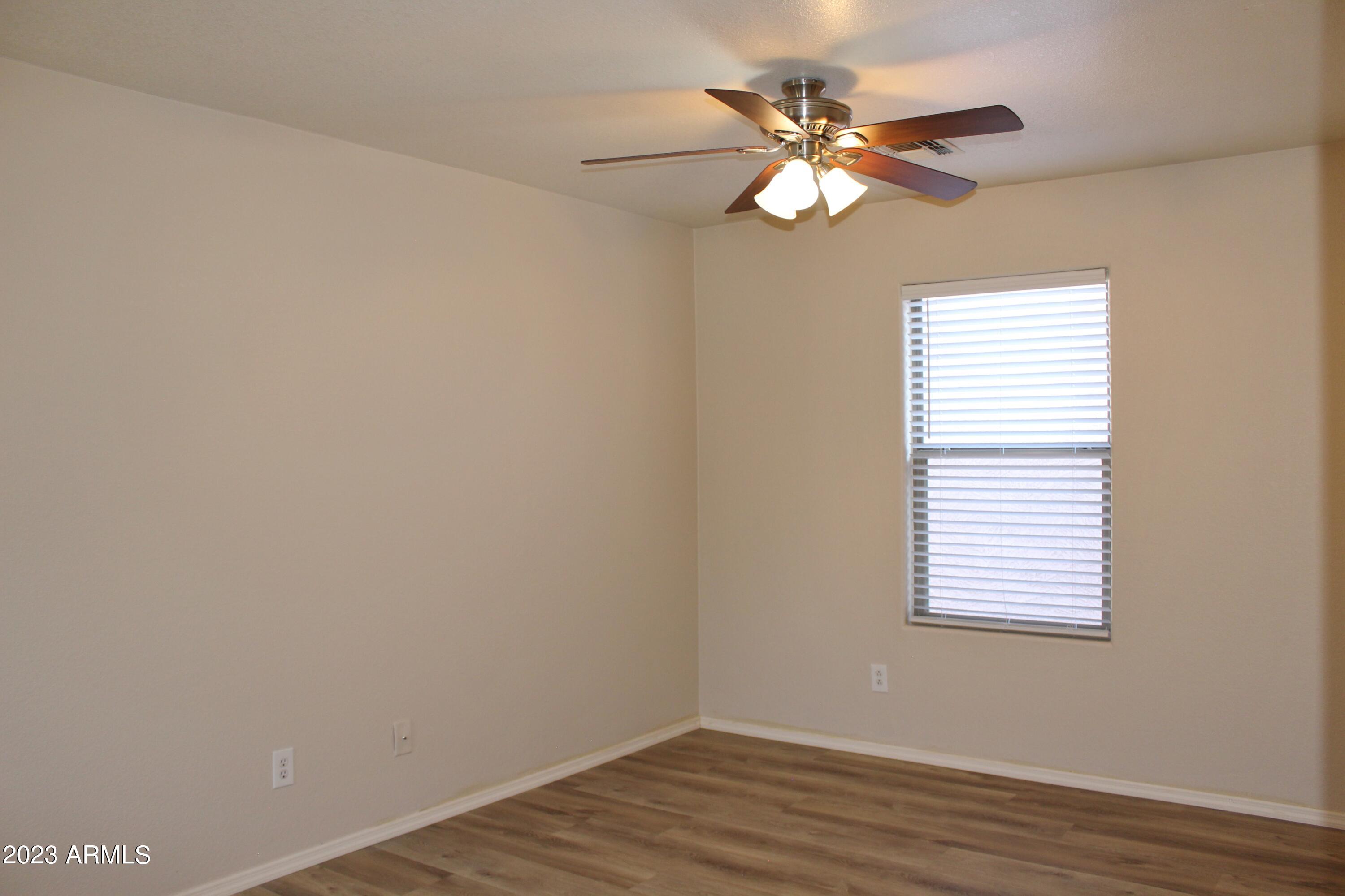 17278 North 184th Drive Surprise, AZ 85374 - Photo 16 of 32 a view of an empty room with wooden floor and a window