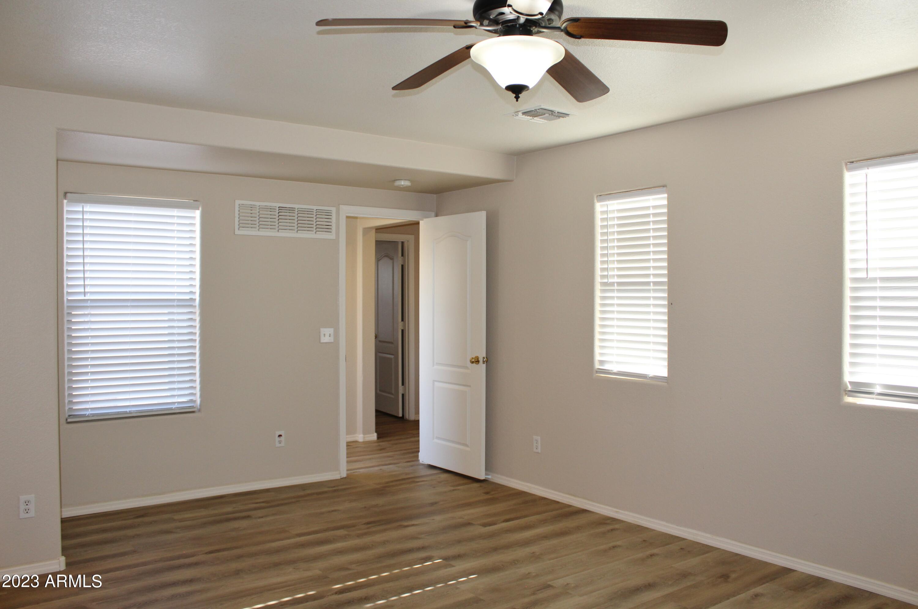 17278 North 184th Drive Surprise, AZ 85374 - Photo 21 of 32 a view of an empty room with wooden floor and a window