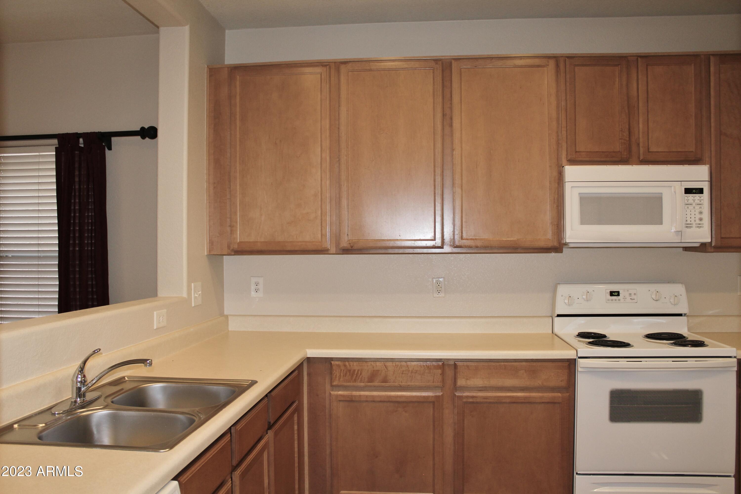 17278 North 184th Drive Surprise, AZ 85374 - Photo 6 of 32 a kitchen with a sink cabinets and stainless steel appliances