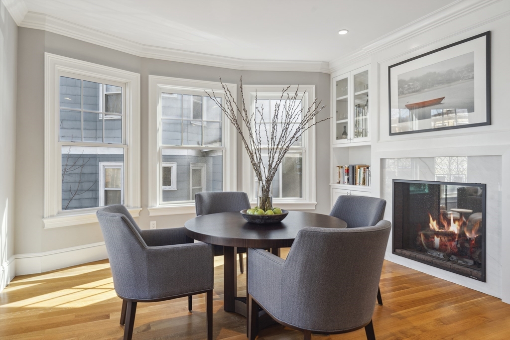 73 Upland Road Cambridge, MA 02140 - Photo 14 of 42 a dining room with furniture a fireplace and wooden floor