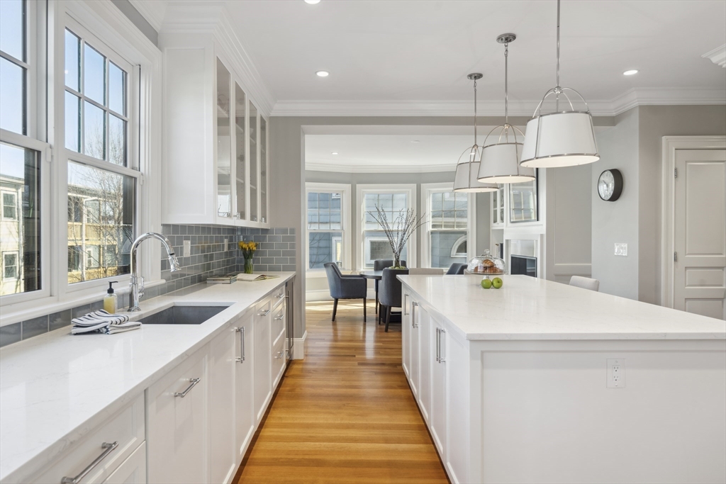 73 Upland Road Cambridge, MA 02140 - Photo 16 of 42 a large kitchen with kitchen island a large counter space a sink appliances and a window