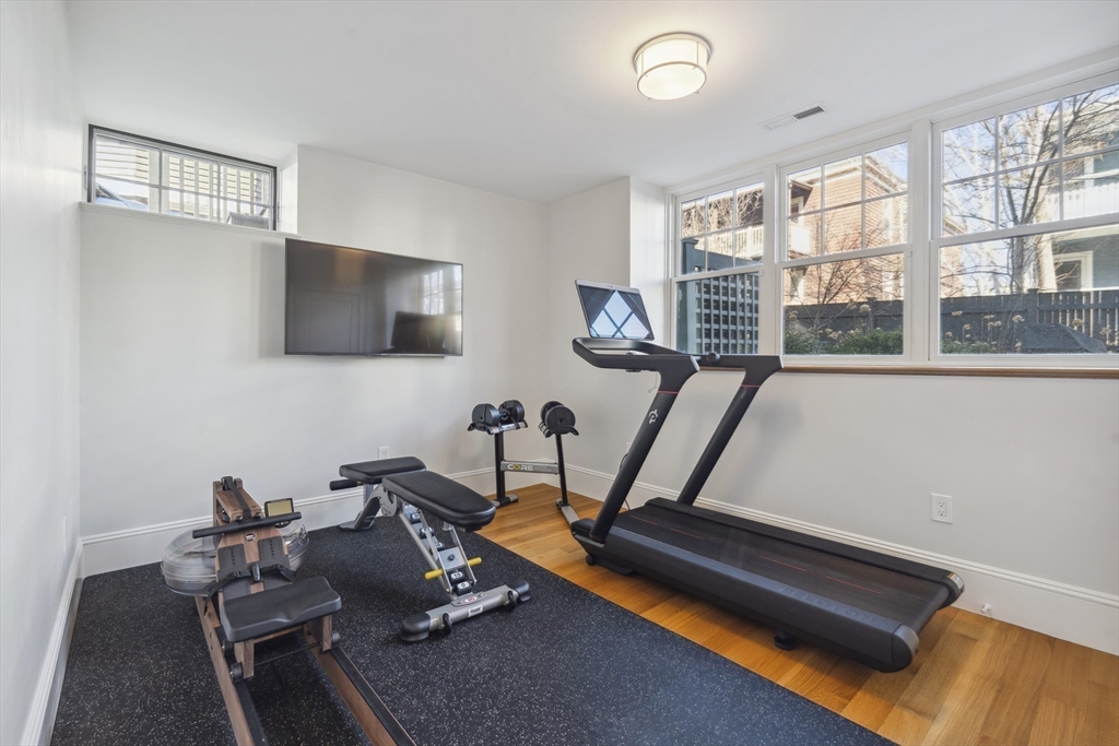 73 Upland Road Cambridge, MA 02140 - Photo 37 of 42 a room with gym equipment and a flat screen tv