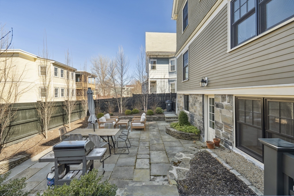 73 Upland Road Cambridge, MA 02140 - Photo 40 of 42 a view of a patio with couple of chairs and a fountain