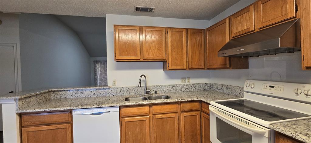 2224 Limestone Lane Garland, TX 75040 - Photo 6 of 16 a kitchen with granite countertop stainless steel appliances a sink stove and cabinets
