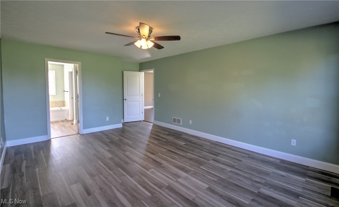 4998 Wayne Road Mantua, OH 44255 - Photo 18 of 43 master bedroom with ceiling fan, connected bathroom, and dark wood-type flooring