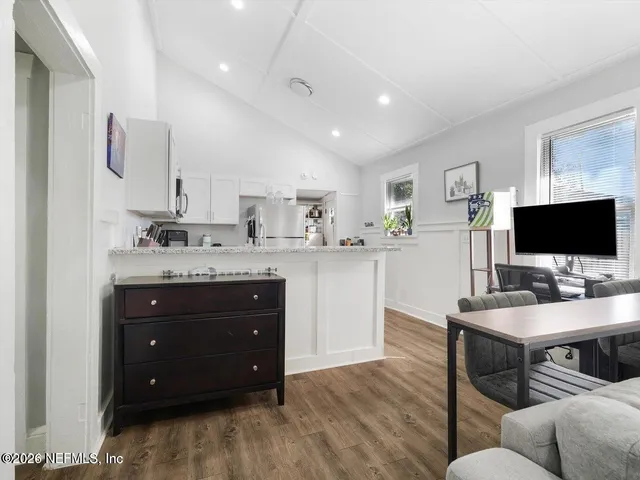 a living room with stainless steel appliances kitchen island granite countertop furniture and a flat screen tv