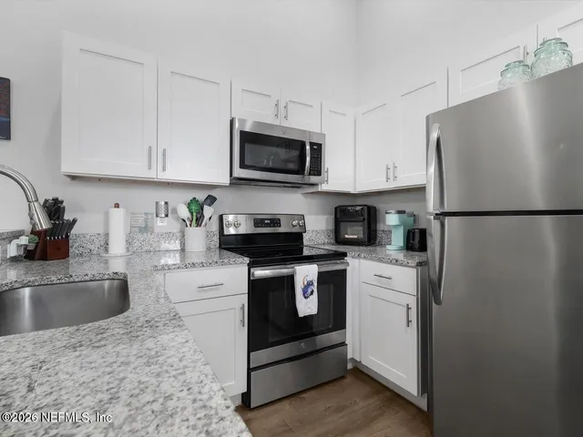 a kitchen with stainless steel appliances granite countertop a refrigerator sink and stove