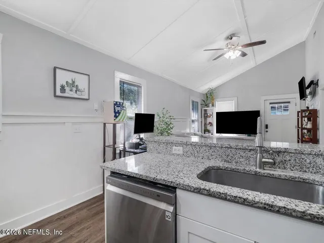 a living room with granite countertop furniture a fireplace and a flat screen tv