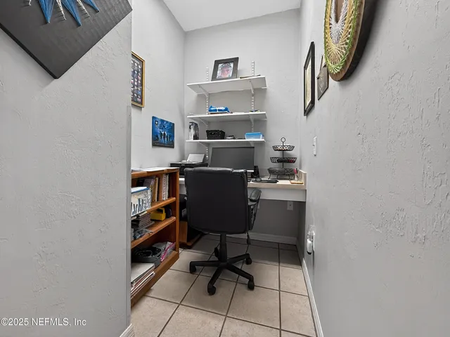 a view of a workspace with furniture and a window