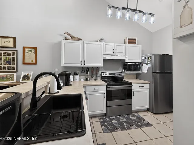 a kitchen with kitchen island a stove a sink and a refrigerator