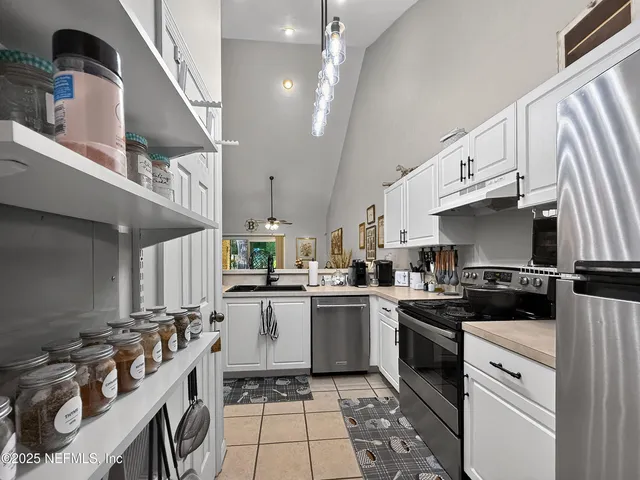 a kitchen with a sink a stove top oven and cabinets