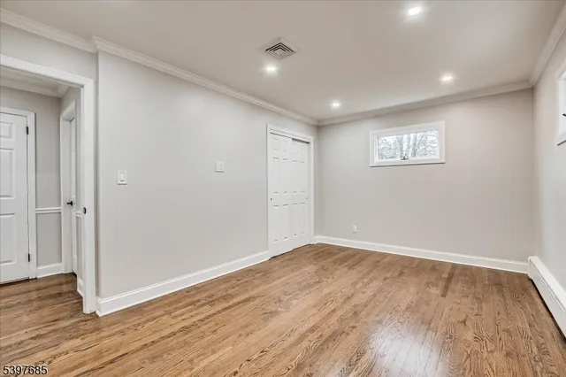 a view of empty room with wooden floor