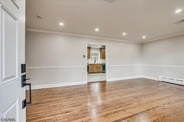 a view of empty room with wooden floor