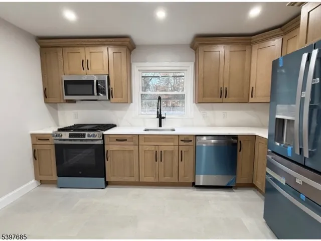 a kitchen with stainless steel appliances granite countertop a stove microwave and refrigerator