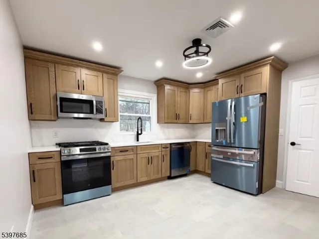 a kitchen with stainless steel appliances granite countertop a stove sink microwave and refrigerator