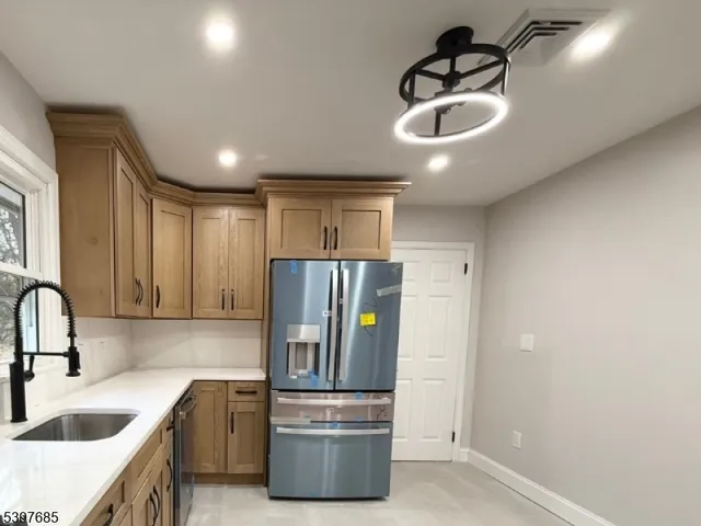 a kitchen with stainless steel appliances granite countertop a sink and a refrigerator