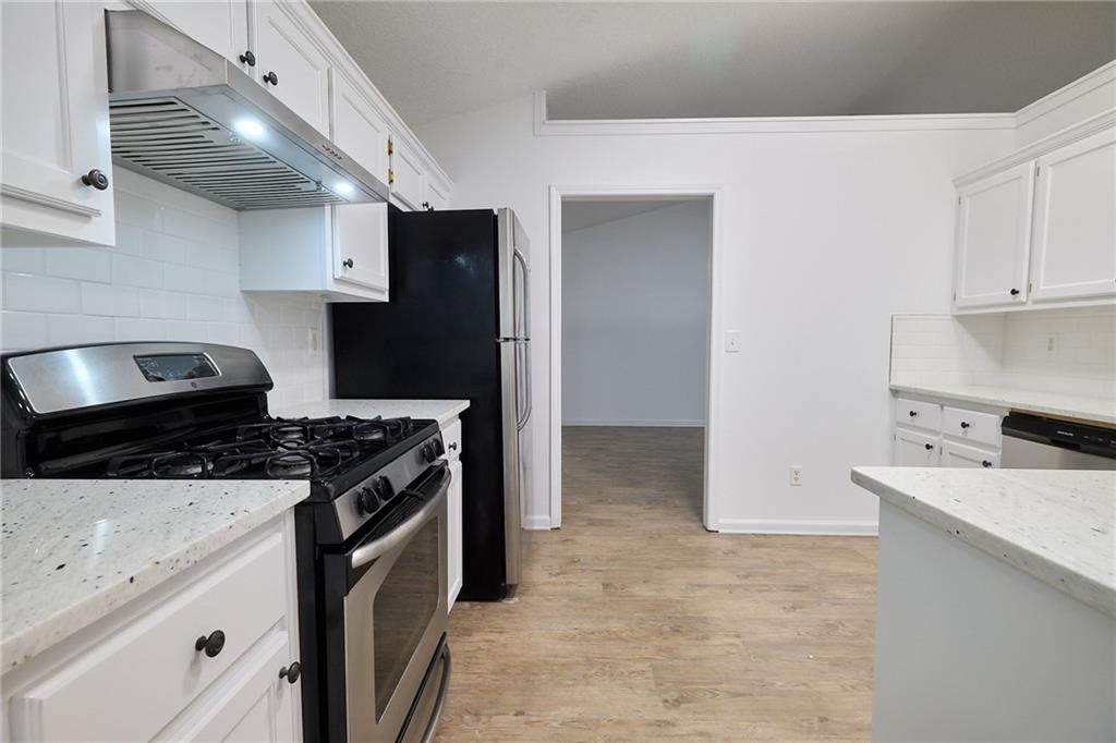 1645 Fort Mason Way Dacula, GA 30019 - Photo 12 of 28 a kitchen with a stove and a refrigerator