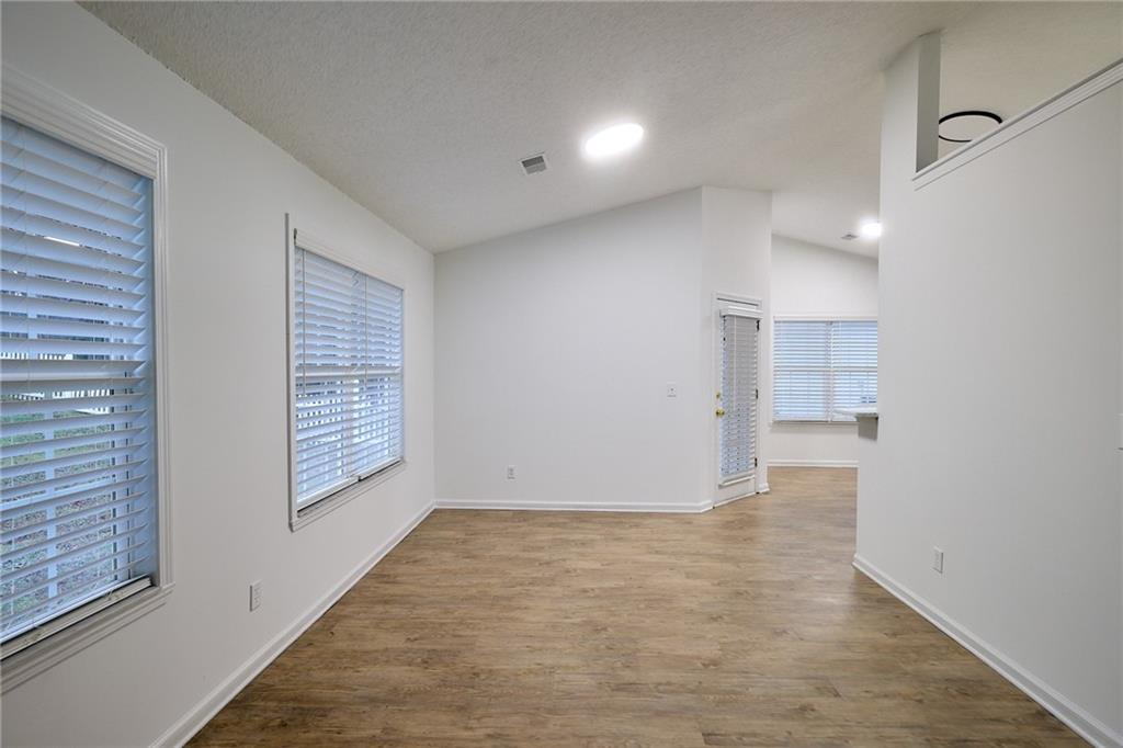 1645 Fort Mason Way Dacula, GA 30019 - Photo 8 of 28 a view of an empty room with wooden floor and a window