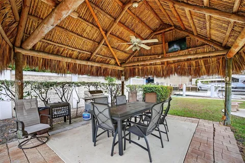 a view of a patio with a table and chairs and a barbeque