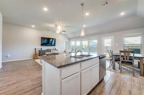 a kitchen with sink stove and dining table