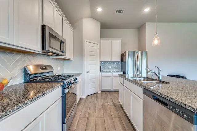 a kitchen with stainless steel appliances granite countertop a stove and a sink