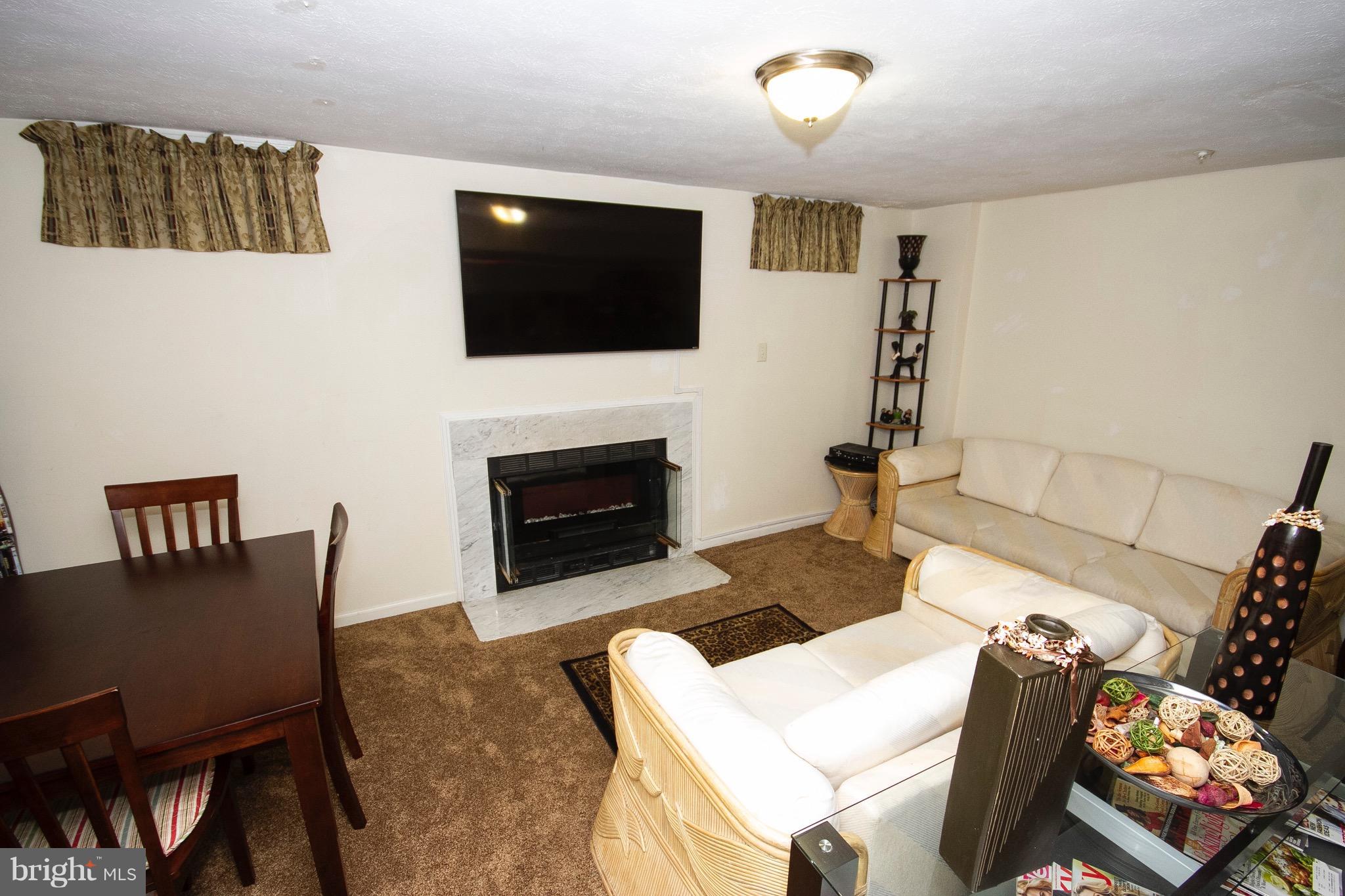 4201 Red Haven Road Baltimore, MD 21208 - Photo 21 of 29 a living room with furniture a flat screen tv and a fireplace