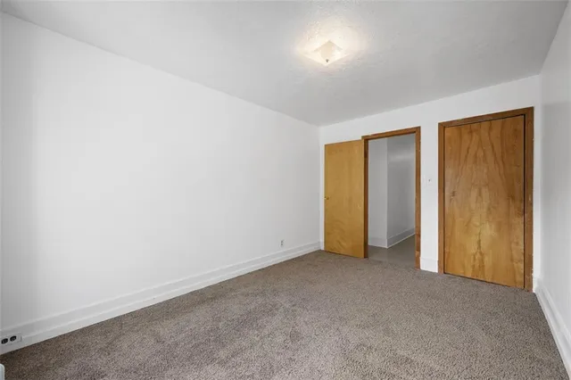 a bathroom with a granite countertop toilet a sink and a mirror