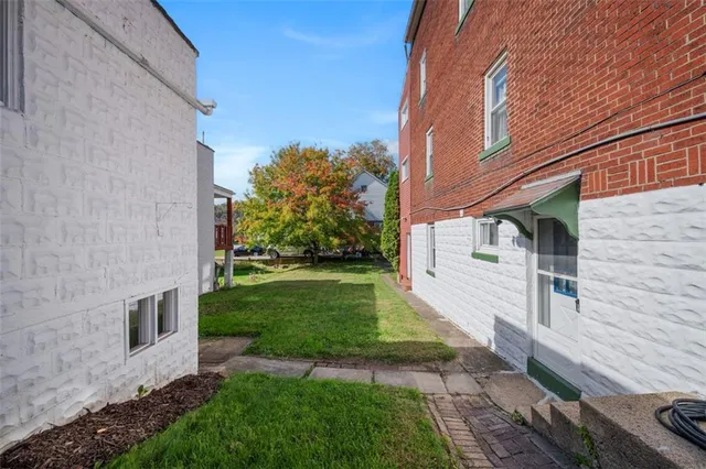 a view of a house with backyard and a tree