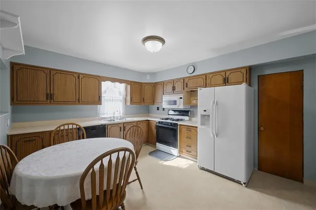 a kitchen with refrigerator and chairs