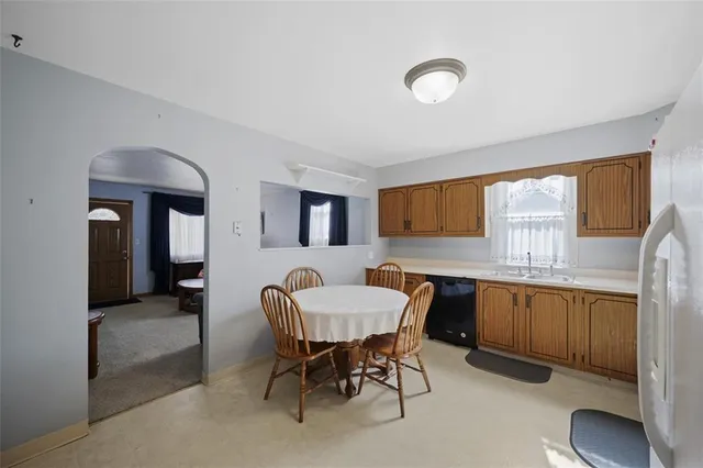 a kitchen with a dining table chairs and window