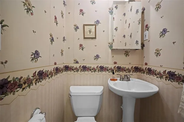 a bathroom with a sink and mirror with toilet