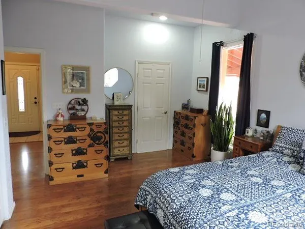 a bedroom with a bed and painting on the wall