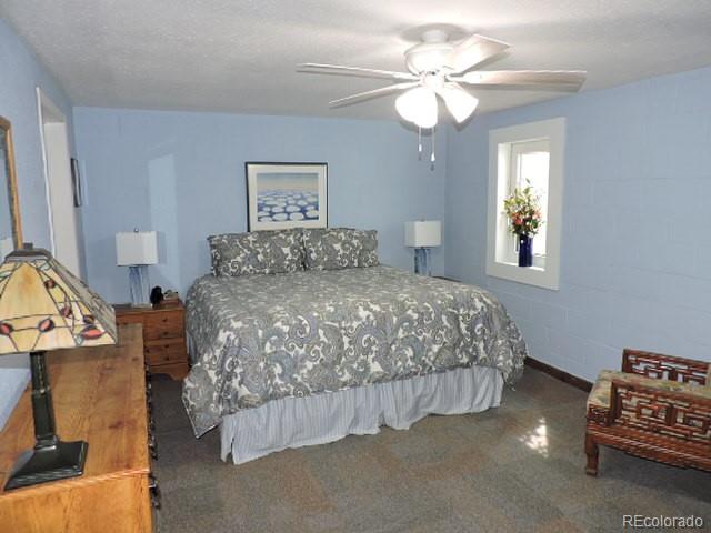 3818 Fontaine Road Fort Garland, CO 81133 - Photo 26 of 50 a bedroom with a bed and a chandelier