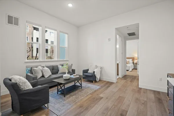 a living room with furniture and a wooden floor