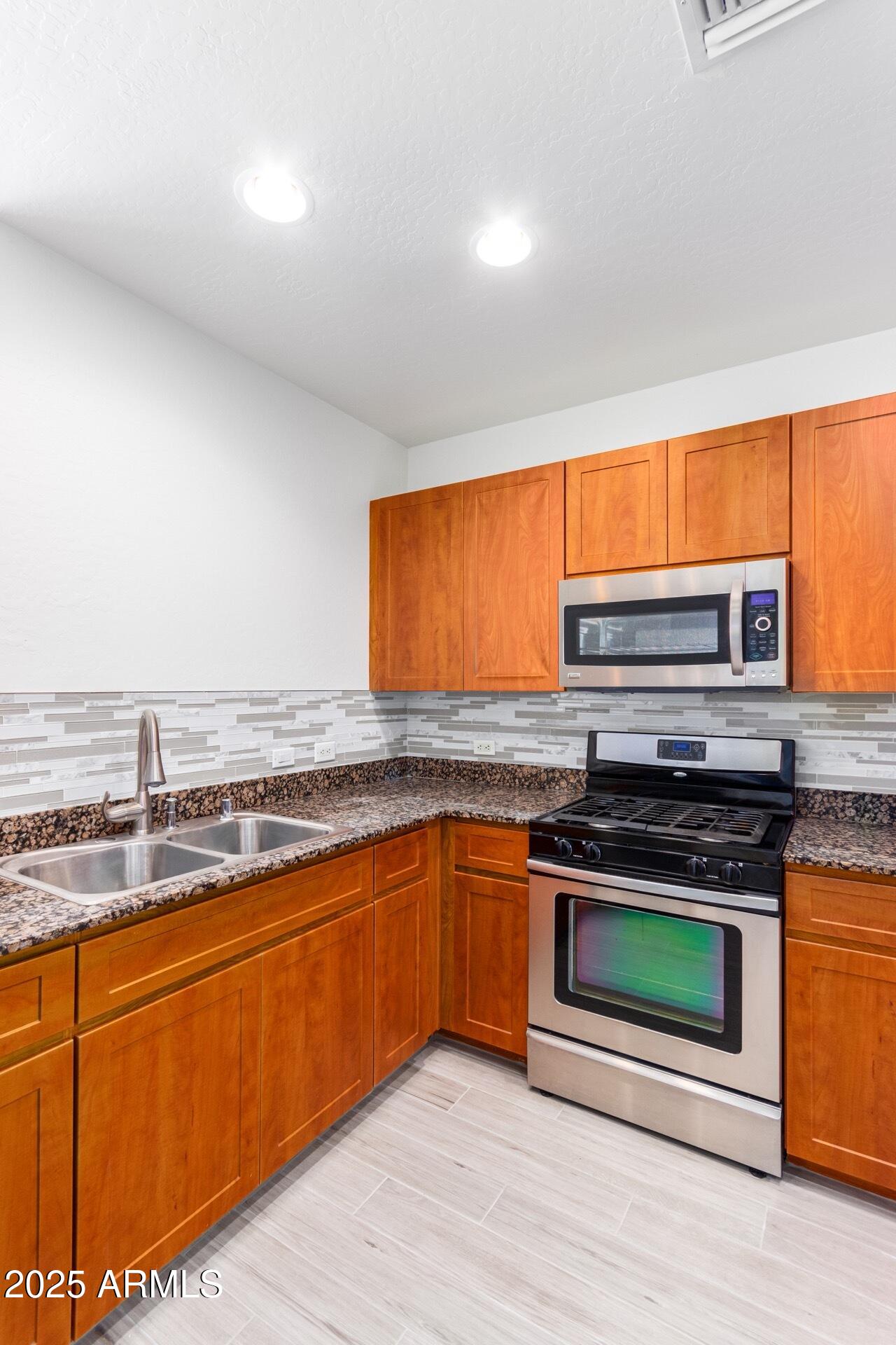 17 West Vernon Avenue, Unit 117 Phoenix, AZ 85003 - Photo 15 of 38 a kitchen with stainless steel appliances granite countertop a stove a sink and a microwave