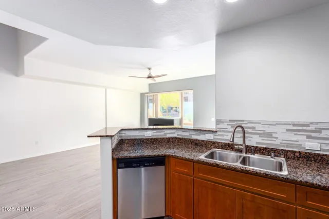 a kitchen with stainless steel appliances granite countertop a sink a microwave cabinets and wooden floor