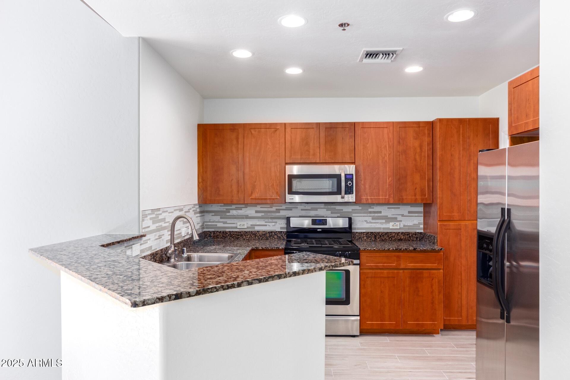 17 West Vernon Avenue, Unit 117 Phoenix, AZ 85003 - Photo 6 of 38 a kitchen with stainless steel appliances granite countertop a sink a stove and refrigerator