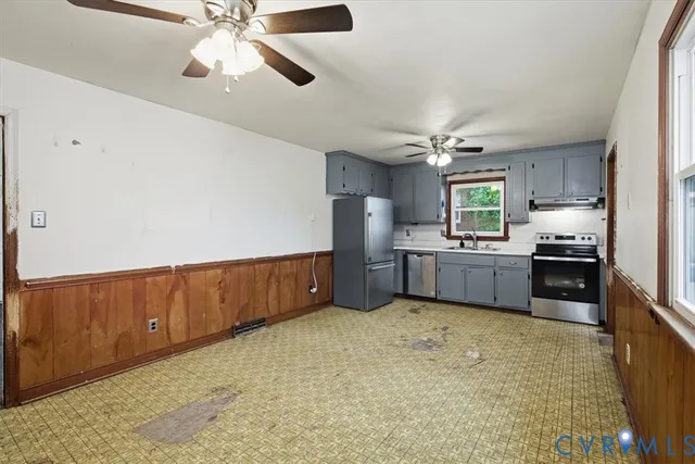 a kitchen with stainless steel appliances kitchen island granite countertop a refrigerator a sink and dishwasher