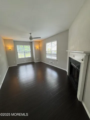 an empty room with windows and fireplace