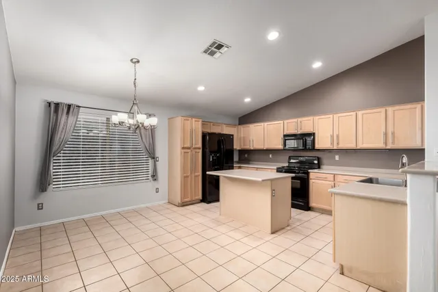 a kitchen with stainless steel appliances kitchen island granite countertop a refrigerator a stove a sink dishwasher and a refrigerator with wooden floor