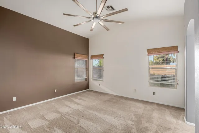 an empty room with windows and fan