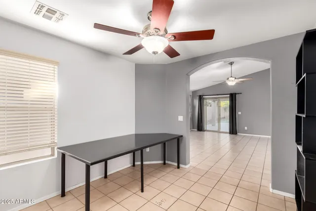 a view of a livingroom with a table and chair with a chandelier fan