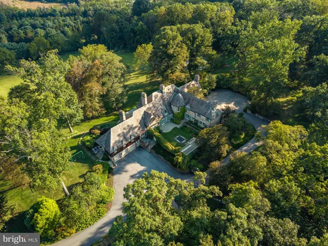 an aerial view of a house with a garden and swimming pool